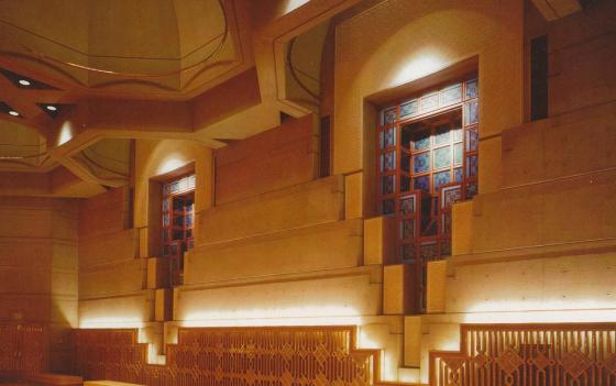 Ismaili Jamatkhana and Centre, Burnaby, The main side windows as seen in the interior of the prayer hall Says Bruno Freschi: "An example of 'going out' That ephemeral quality of spiritual space can be best seen in the calligraphy on the glazing of the windows. The glass is one inch thick providing acoustic insulation. The graphics are fired on both surfaces of the glass. Seen at an angle, the calligraphic images are dual and ambigious, they visually vibrate to the comtemplative viewer. This is 'signalectic' architecture, the threshold of the ephemeral sanctuary of spiritual space."