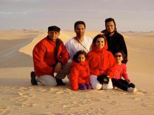 Arif Babul pictured with his wife, two daughters, his mother and late father in the sand dunes in Egypt. Professor Babul attributes his accomplishments to the sacrifices of his parents and the support of his family.