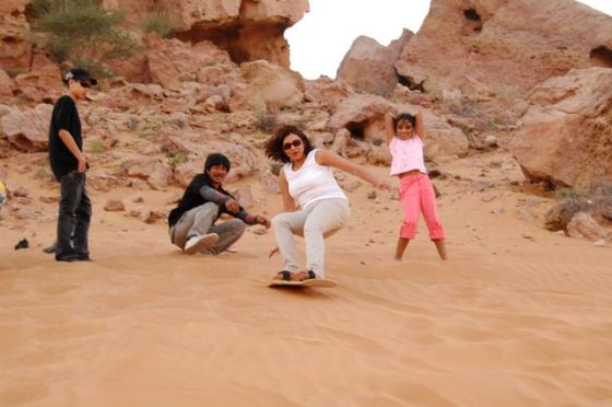 Naznin, Arif's high school sweetheart, taking on a sandboarding challenge on a desert dune in Dubai