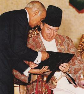 Mawlana Hazar Imam conferring the title of Diwan on Shafik Sachedina in Lisbon, with both figures engaged in a ceremonial moment.