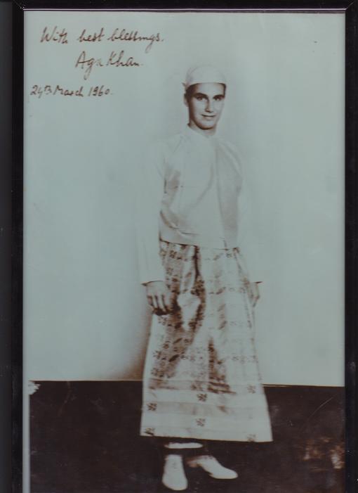 A signed photo of His Highness the Aga Khan, 49th Ismaili Imam. He is pictured in a traditional Burmese dress during his March 1960 visit to Burma when he celebrated Navroz with the Rangoon Jamat. Photo: Anwar Virani Archives, Ottawa