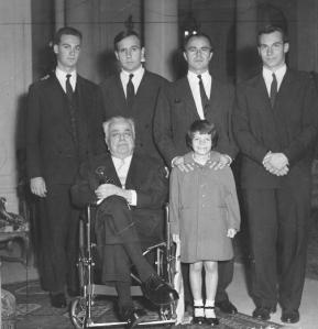 The late 48th Ismaili Imam, His Highness the Aga Khan, seated on a wheelchair with members of his family with his successor, the present Imam, Prince Karim Aga Khan, standing at extreme right. Others in the photo (l to r), grandson Prince Amyn Muhammad, and the late Imams two sons, the late Prince Sadruddin and Prince Aly Khan, who is seen holding his daughter Princes Yasmin Aga Khan Photo: Zul Khoja Collection, Ottawa.