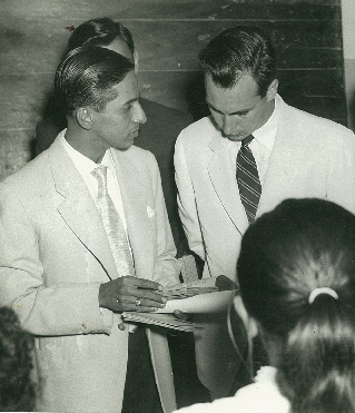 Lourenço Marques, 1958: His Highness the Aga Khan, direct descendant of the Prophet Muhammad (s.a.s.) and current 49th hereditary Imam of the Shia Ismaili Muslims is seen taking a keen interest as Alwaez Jehangir explains the Gujarati history texts that were used to impart religious education to Ismaili youth in Mozambique.