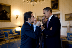 Former U.S. President Barack Obama engages in discussion with French President Nicolas Sarkozy in the Blue Room of the White House.