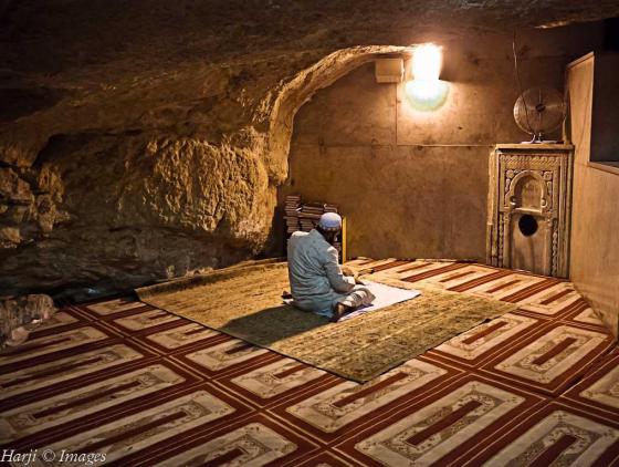 A pilgrim offering prayers under the "Rock" where Abraham brought his son Ishmael for sacrifice.