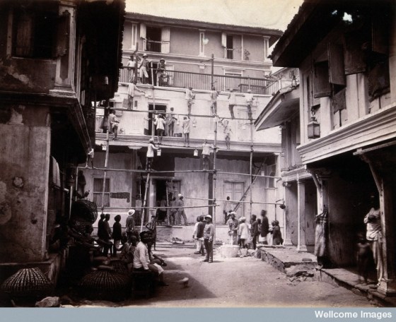 plague house being whitewashed by men standing on scaffold Credit: Wellcome Library, London. Wellcome Images images@wellcome.ac.uk http://wellcomeimages.org A plague house being whitewashed by men standing on scaffolding in Bombay. Photograph, 1896. Photo Credit: Credit: Wellcome Library, London. Wellcome Images