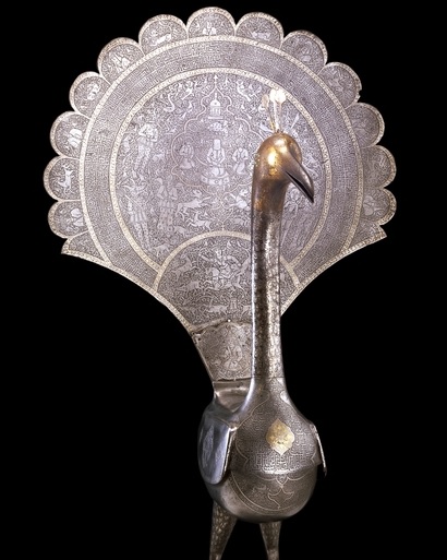 This fine steel peacock may have decorated the cross-bar of an alam, a standard carried during religious festivals in Iran. Hazrat Ali and his two sons, Hasan and Husayn, are depicted in the central medallion on the peacock’s fanned tail. The bird is also engraved with stylized inscriptions, princely hunting scenes, human busts and animals in a style typical of the Qajar period (1771-1924) in Iran. Photo Credit: The Trustees of the British Museum. Copyright