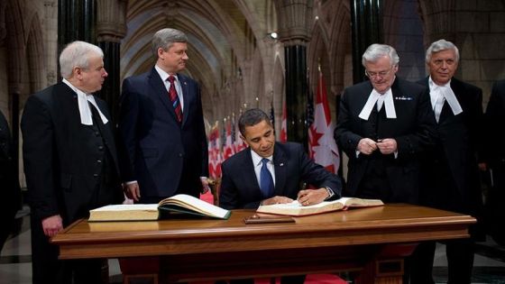 President Barack Obama signs the guest book in Parliament Hill during his visit to Ottawa shortly after becoming the US President. Prime Minister Stephen Harper is standing to President Obama's right. Photo: Whitehouse.