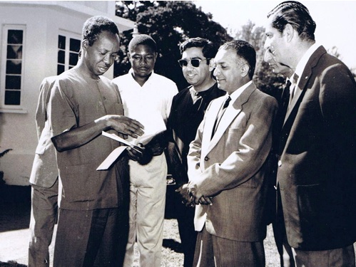 A rare photo of Arusha's Ismaili leaders with Mwalimu Julius Nyerere taken during a community donation in the late 1960's. (L to R) -- The late Tanzanian President Julius Nyerere, Hashim Mbita, press secretary to the president, Akber Natha Hirji, a member of Ismaili regional council, Mukhi Kamrudin Hasham Jessa, Kamadia Madat Vassanji, and Moosa Janmohamed, also a member of the regional council headquartered in Moshi. The photo was taken during at the guest house for the president in Arusha. The donation was for a local community project. Photo credit: www.Juliusnyerere.info