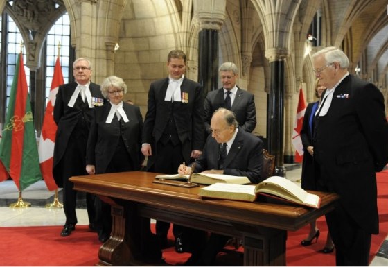 His Highness the Aga Khan signs the visitors books for the House of Commons and the Senate in the Canadian Parliament Rotunda as Prime Minister Stephen Harper, his wife Laureen Harper, The Honourable Andrew Scheer, Speaker of the House of Commons and the Honourable Noël Kinsella, Speaker of the Senate look on. Photo credit: TheIsmaili/Gary Otte.