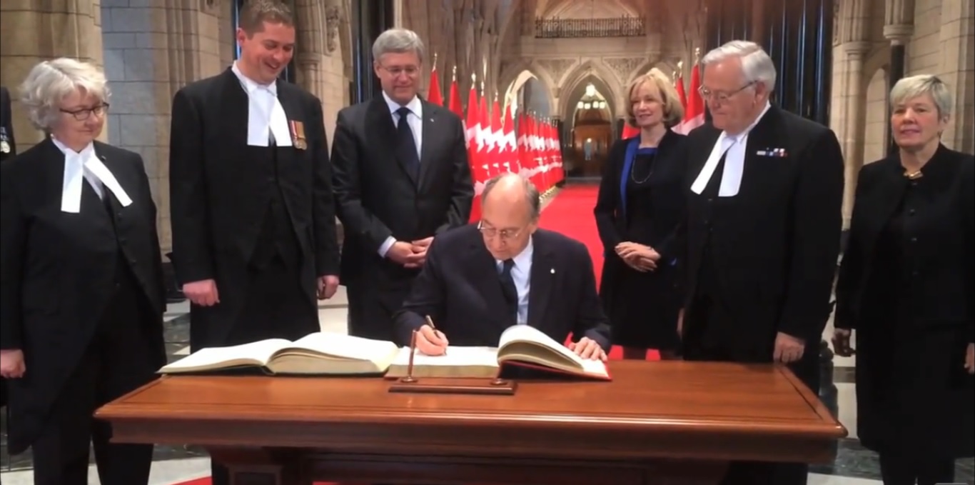  Mawlana Hazar Imam signs the distinguished visitors books for the House of Commons and the Senate in the Canadian Parliament Rotunda as Prime Minister Stephen Harper, his wife Laureen Harper, The Honourable Andrew Scheer, Speaker of the House of Commons and the Honourable Noël Kinsella, Speaker of the Senate, and other individuals look on. Photo: Post Media Clip 