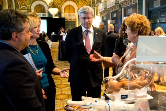 Prime Minister Stephen Harper receiving an explanation about an exhibit displaed at the summit Saving Every Woman, Every Child: Within Arm’s. Phooto: The website of the Prime Minister of Canada.