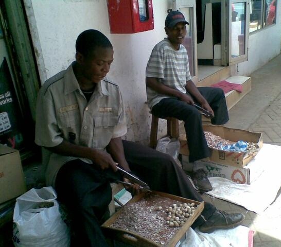 Sopari cutters sit outside the paan shop totally engrossed in cutting soparis with a commercial sopari cutters. Photo: Farida Keshavjee.