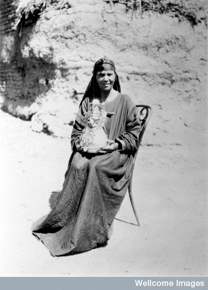 A midwife in Upper Egypt holding a kulleh pot. Also known as the goollah, it is a porous water-jar of sun-dried Nile mud. Photo Credit: Winifred S. Blackman/ Wellcome Library Image, London. 