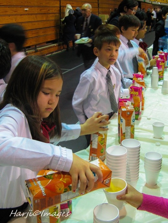Junior Ismaili Volunteers serving juice at a jamati jaman (feast). Please click on photo for photo essay. Photo: Muslim Harji. 