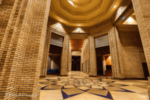 Interior view of a beautifully designed space with brick walls and intricate geometric patterns on the floor.