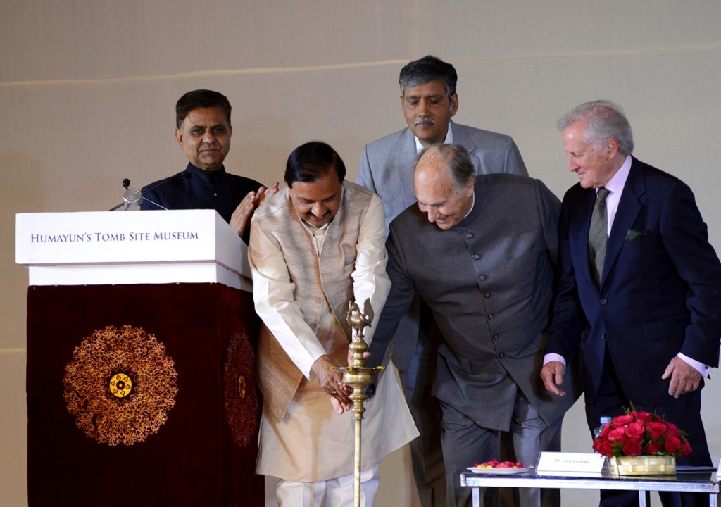 A group of dignitaries, including India's Minister of Tourism and Culture, participating in the inauguration ceremony of the Humayun Tomb Site Museum, with one person lighting a ceremonial lamp.