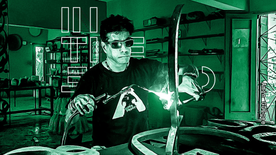 Amin Gulgee performing metalwork in his studio, wearing protective gear and focused on his craft.