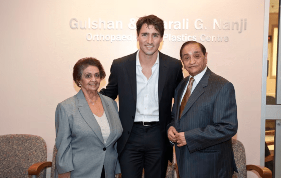 Pyarali and Gulshan Nanji posing with a man in formal attire at the opening of the Orthopaedic Plastics Centre, with a sign displaying their names in the background.